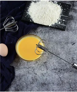 Stainless steel semi-automatic egg whisk detail showing kitchen baking tool for eggs and cream.