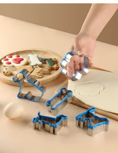 Detailed view of cute dog shaped cookie cutters in use, shaping soft dough on wooden board.
