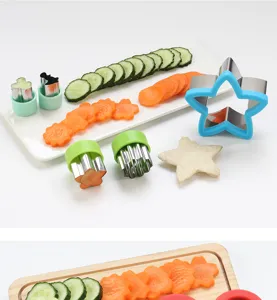 Stainless steel vegetable fruit cutter detail view showing shaped cucumber and carrot slices.