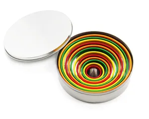 Detalle de cortadores de galletas redondos coloridos anidados en lata metálica.