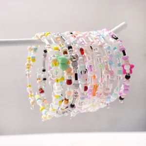 Colorful DIY glass seed bead and charm layered bracelet detail view for handmade jewelry.