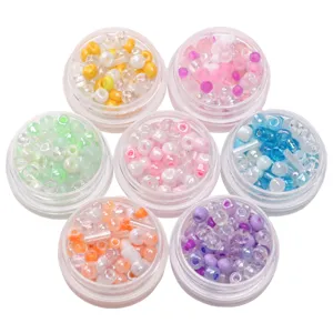 Mixed DIY glass seed beads and tube beads set in six small jars for handmade jewelry making.