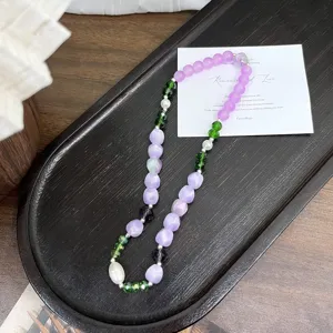 Detailed view of colorful DIY beaded necklace featuring resin gradient and crystal beads on tray.