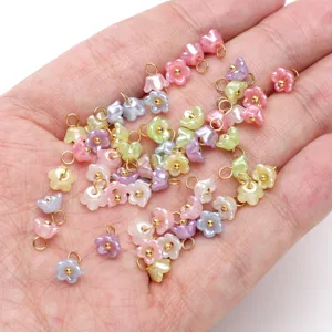Pearlescent resin mini flower pendants with metal loops for DIY bracelet jewelry making.