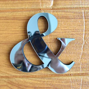 Adesivo murale con simbolo e ampersand specchiato in acrilico, dettaglio decoro riflettente.