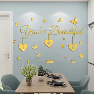 Vista dettagliata dell'adesivo murale acrilico dorato con frase in inglese e farfalle.
