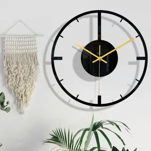 Détail d'horloge murale moderne minimaliste en acrylique noir, élégantes aiguilles dorées.