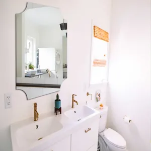 Decorative wall mirror with unique scalloped shape for bathroom vanity and home decor use.
