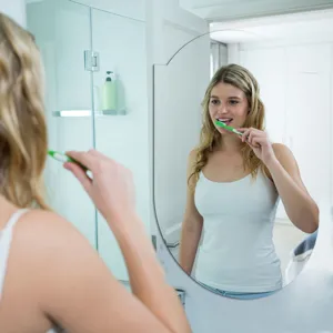 Modern oval decorative mirror sticker for bathroom wall, elegant home interior detail view.