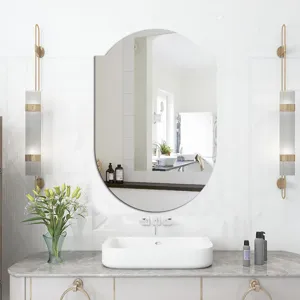 Modern oval bathroom wall mirror with decorative sconces for elegant vanity room decor.