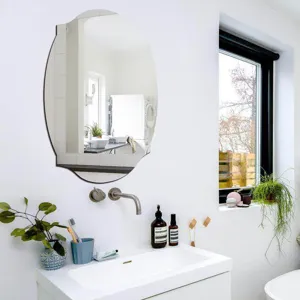 Decorative oval wall mirror with unique wavy edge for modern bathroom decor detail view.