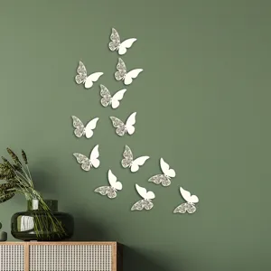 Detail shot of 3d hollow paper butterfly wall stickers arranged on green wall for room decor.