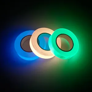 Primer plano detallado de tres cintas adhesivas luminosas coloridas que brillan en la oscuridad.