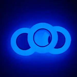 Primer plano detallado de rollos de cinta luminosa que emiten luz azul brillante.