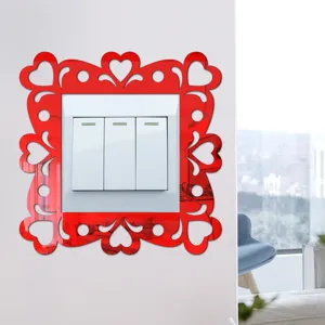 Close-up detail of the red reflective acrylic heart switch sticker mounted on a white wall.