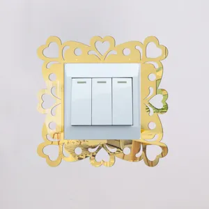 Gold acrylic mirror light switch sticker with heart cutout design for modern home decor.