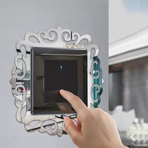 Detail shot of decorative acrylic mirror wall switch sticker featuring a stylish carved frame.