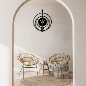 Horloge murale moderne en acrylique noir abstrait avec aiguilles dorées et détail géométrique.