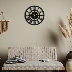 Pendule murale noire en acrylique minimaliste avec chiffres romains dans un intérieur moderne.