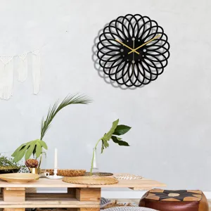 Vue détaillée de l'horloge murale en acrylique noir avec aiguilles dorées dans un intérieur.