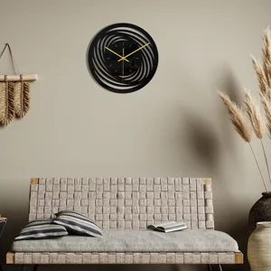 Moderne horloge murale en acrylique noir avec design tourbillon creux abstrait et aiguilles dorées.