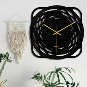 Gros plan de détail de l'horloge murale abstraite noire moderne aux aiguilles dorées.