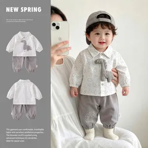 Infant baby boy spring clothes set featuring white shirt with dinosaur patch and grey pants