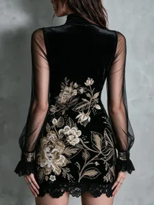 Detailed back view of black embroidered dress with mesh sleeves and floral patterns