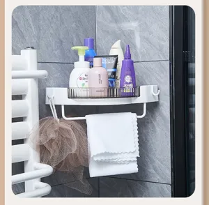 White bathroom corner storage shelf detail, rotating tray design with towel bar and hooks.