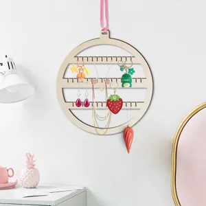 Dettaglio del espositore per gioielli rotondo in legno appendibile con ganci multipli per accessori.