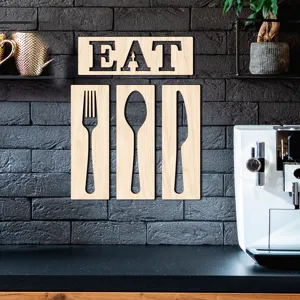 Décoration murale créative en bois EAT avec découpes de couverts fourchette cuillère et couteau.