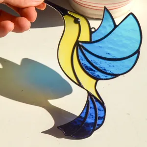 Detailed close-up of a vibrant stained glass hummingbird suncatcher pendant for home window hanging.