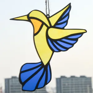 Detail of hummingbird suncatcher, colorful acrylic hanging ornament for window decor.