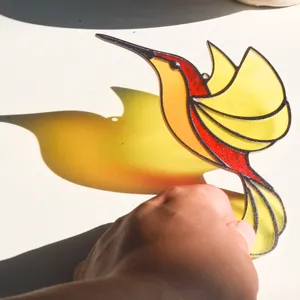 Stained glass hummingbird suncatcher detail, vibrant red and yellow acrylic hanging window decor.
