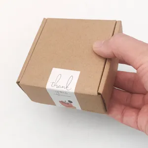 Toma de detalle de la caja de cartón marrón con pegatina de agradecimiento, vista limpia.
