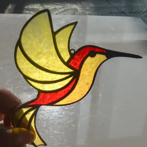 Stained glass hummingbird suncatcher pendant detail showing vibrant yellow and red acrylic colors.