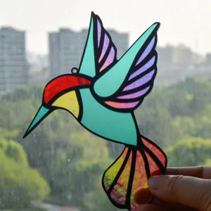 Stained glass hummingbird suncatcher detail, colorful acrylic hanging decor for window.
