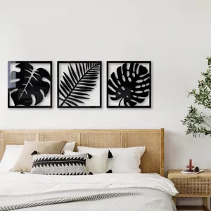 Vue détaillée de stickers muraux en acrylique noir motif feuilles tropicales dans une chambre.