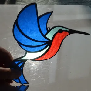 Stained glass hummingbird suncatcher detail, colorful acrylic hanging window ornament art.