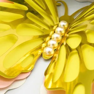 Close-up detail of a stunning 3D metallic gold butterfly wall sticker with pearl body accents.