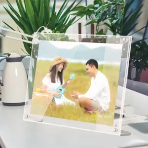 Clear acrylic photo frame detail showing transparent double layers and sturdy metal desk stand.