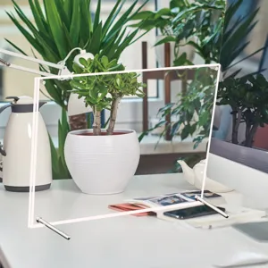 Clear acrylic photo frame detail showing transparent panels and metal desktop support stand.