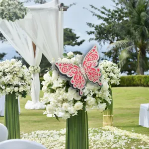 Detailed view of the 3d hollow paper butterfly decoration set on white floral wedding setup.