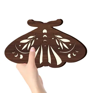 Primo piano del dettaglio decorazione murale falena in legno boho con scultura di fasi lunari.