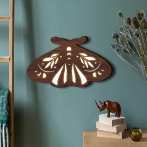 Dettaglio lampada da parete in legno LED con intaglio di fase lunare e stile boho chic.