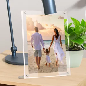 Acrylic photo frame detail showing transparent double layer design with metal screws on desk setup.