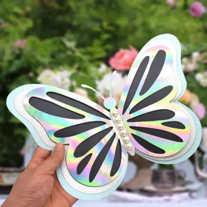 Close-up detail of large 3D hollow butterfly wall sticker with pearl decor for party.