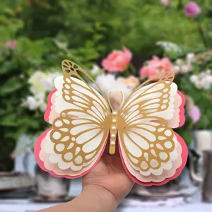 Detailed view of 3d layered paper butterfly with hollow gold pattern and pearl decor.