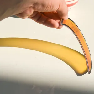 Dettaglio acrilico acchiappasole a mezzaluna con sfumatura arancione e effetto ombra.
