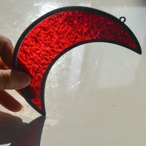 Dettaglio acchiappasole a mezzaluna in vetro colorato rosso decorazione finestra